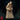 Robed male figure standing upright, cradling a small skull totem in both hands, wearing a heavy cowl and rope belt with bone bead necklace. Grim, bearded expression. Sculpt by Monster Atlas.