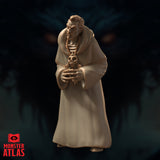 Robed male figure viewed from a low frontal angle, both hands raised to present a skull totem, wide cowl draped across the shoulders, rope belt cinching the robe at the waist. Sharp, intense facial expression. Sculpt by Monster Atlas.