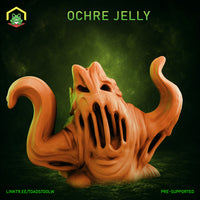 Ochre Jelly miniature by The Toadstool Weaver — a bulbous ooze creature with outstretched pseudopod limbs, a hollow skull-like face with sunken eye slots and a wide vertical maw, surface covered in flowing ridges and deep organic channels.