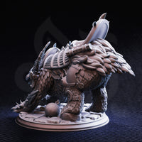 Rear three-quarter digital render of Old Betty War Owlbear miniature, unpainted grey, revealing the back armour plating with segmented panels, a large ceremonial blade rising from the saddle mount, dense feathered flanks, and a small cannonball on the scenic rubble base — displayed against a dark background