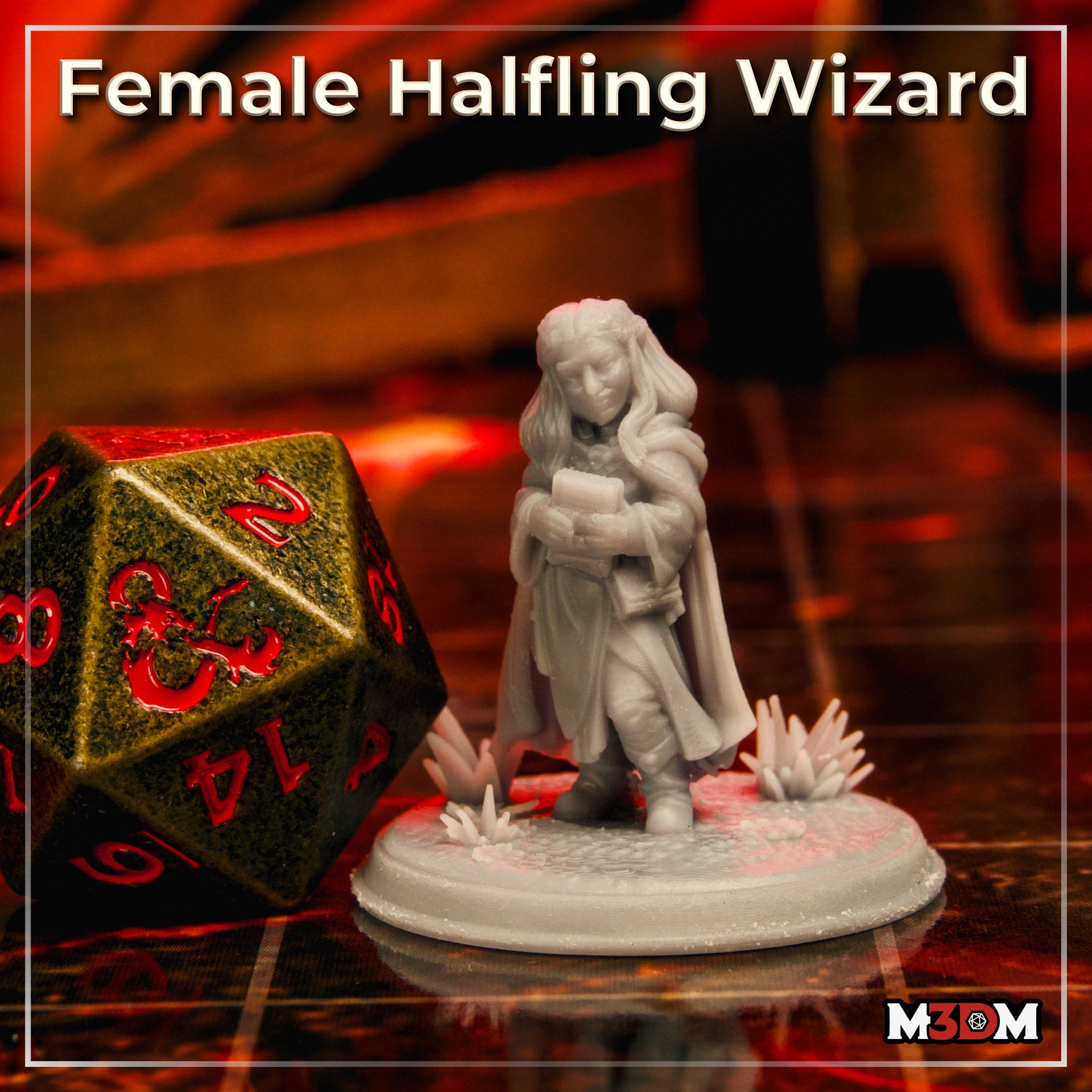 Photograph of a printed and unpainted female halfling wizard miniature next to a large gold and red D20 dice for scale. The grey resin mini shows her in a flowing cloak holding a spellbook, mounted on a crystal and floral scenic base.
