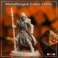 Photograph of an unpainted grey resin Metalforged Grave Cleric miniature printed at 32mm scale, showing the full sculpt with hooded masked face, ankh breastplate, flowing cloak, and spear-staff, pictured alongside a large bronze and red d20 die for scale reference