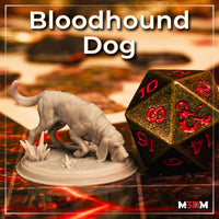 Photograph of an unpainted grey resin bloodhound miniature printed at 32mm scale, shown nose-down in a tracking pose on a scenic base with crystal elements, photographed next to a large metal D20 dice on a battle map