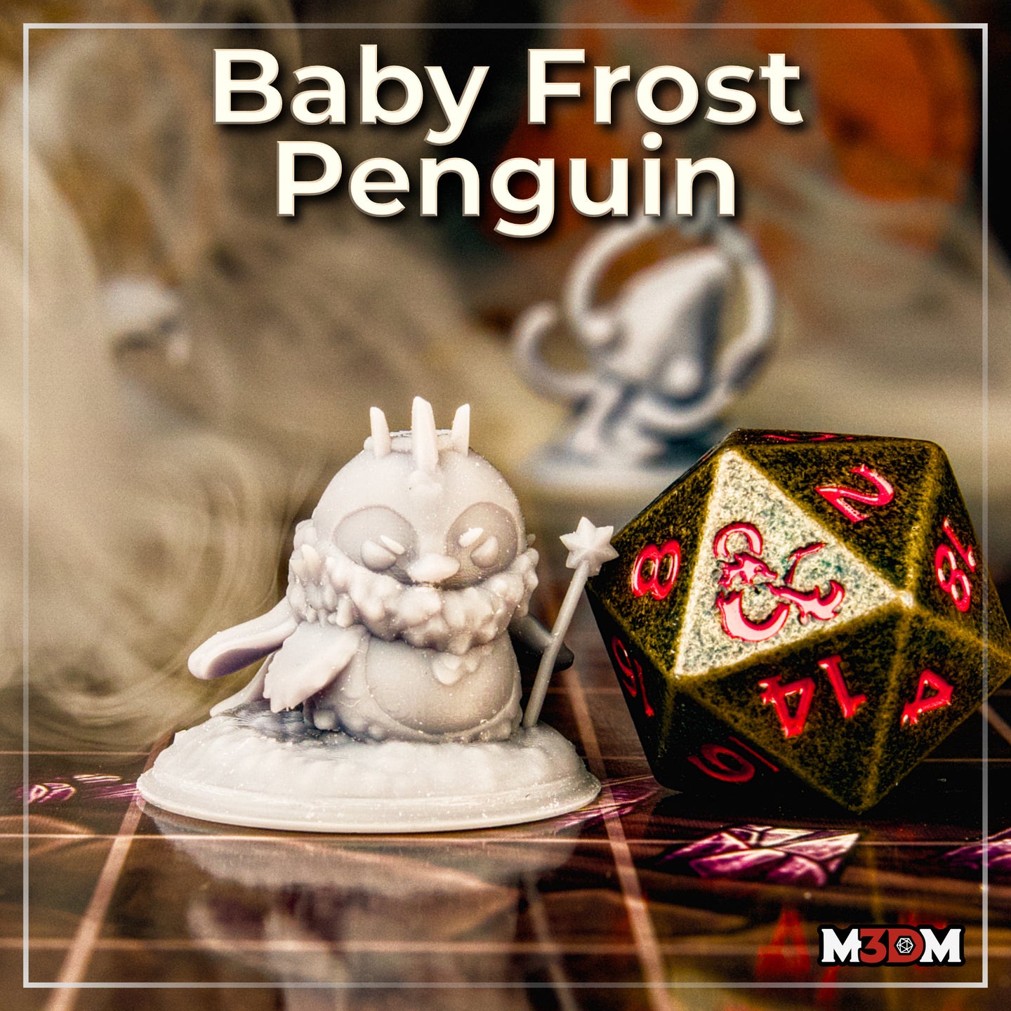 Photograph of the printed Baby Frost Penguin miniature by Mia Kay M3DM — an unpainted white resin mini shown next to a large gold and red metal d20 on a tabletop gaming mat, showing the full sculpt with its ice-spike crown, expressive face, textured feathers, and star-headed staff