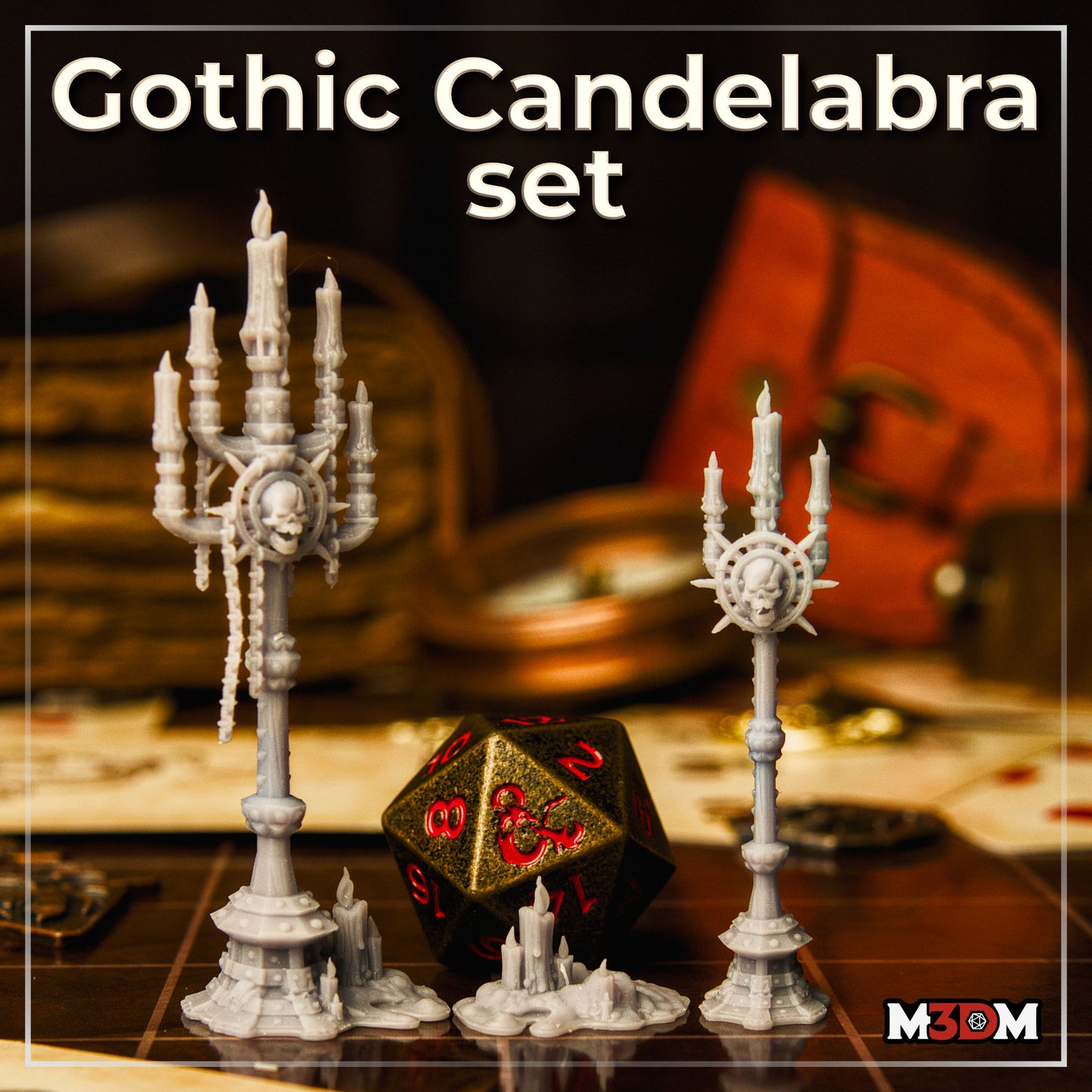Photograph of printed unpainted grey resin Gothic Candelabra Set by Mia Kay M3DM on a tabletop gaming surface — two tall gothic candelabras with skull medallions and a small candle cluster scatter piece shown alongside a large D20 die for scale reference