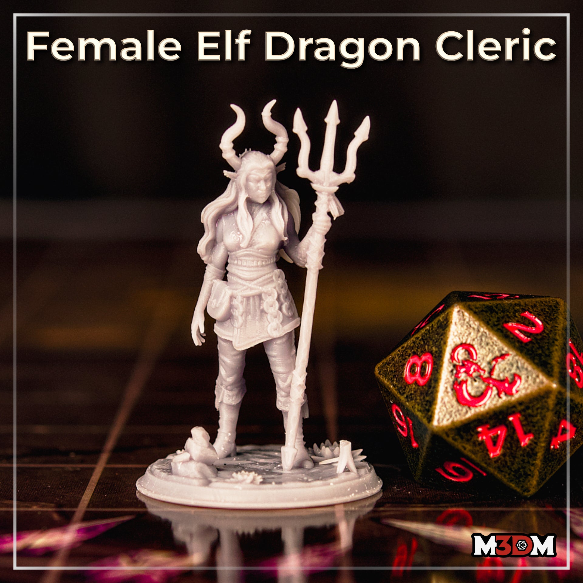 Female elf dragon cleric miniature photographed on a gaming table beside a large d20. Tall horned trident staff, long hair, wrapped bracers, layered tunic with arcane swirl detailing. Unpainted grey resin. Sculpt by Mia Kay M3DM.