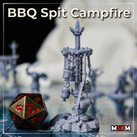 Single BBQ spit campfire terrain piece by Mia Kay M3DM in grey resin, showing chains, meat hooks, small pouches, and bones hanging from a crude crossbar post on a jagged rock base.