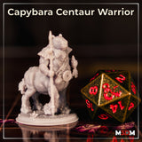 Capybara centaur warrior shown from behind and to the side, revealing thick fur across the haunches and lower body, rope harness crossing the back, bundled talisman charms visible at the shoulder, clawed feet on a scenic base with low plants. Sculpt by Mia Kay M3DM.