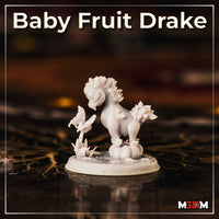 Baby Fruit Drake by Mia Kay M3DM — the same sculpt photographed as a finished grey resin miniature, showing the leaf crown, pumpkin perch, butterfly stem detail, and small floral scatter across the scenic base.