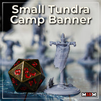 Painted grey prototype of the full ram-skull tundra banner standing next to a large bronze D20 die, showing scale; horned skull at top, bones at crossbeam ends, antler base visible. Sculpt by Mia Kay M3DM.