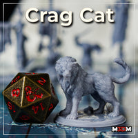 Painted grey crag cat miniature by Mia Kay M3DM beside a large metal D20 die, showing the beast's ferocious snarling head, shaggy mane, and muscular body at tabletop gaming scale.