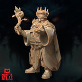 Three-quarter side view of Pikkel Bouldershoulder dwarf druid miniature showing the sweep of his cloak, raised staff with curling vine detail, and the gesture of his conjuring hand — unpainted gold resin by Monster Atlas