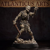 Close-up render of the Atlanticus Arts zombie miniature showing the raised clawing hand, hollow sunken eyes, and decayed armour straps across the chest. The corroded sword is held low at the side. The base is covered in scattered skulls and bones beneath the figure's feet.
