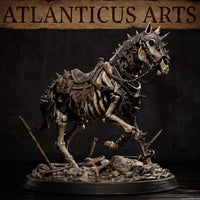 Full skeleton warhorse in a forward-leaning stride pose, spiked armoured barding across head and chest, chain bridle at jaw, leather saddle across bare spine, standing on a rubble and bone-strewn base. By Atlanticus Arts.