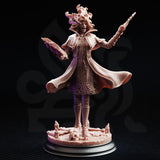 Front view of Professor Margaux de la Croix 32mm resin miniature — unpainted bare resin showing full detail of billowing lattice coat, capelet, raised wand, and decomposed facial features on a candle-and-skull base