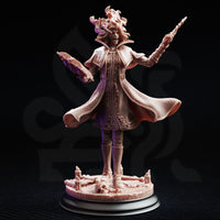 Front view of Professor Margaux de la Croix 32mm resin miniature — unpainted bare resin showing full detail of billowing lattice coat, capelet, raised wand, and decomposed facial features on a candle-and-skull base
