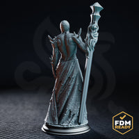Close front view of the Awakened Priest of the Deep One, showing the intricate single cyclopean eye, exposed ribbed torso, layered torn robes, and the staff topped with a geometric angular head. DM Stash sculpt.