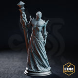 Gaunt cyclopean priest miniature standing upright, raising a tentacle-wrapped staff aloft, tattered robes hanging in strips, chitinous shoulder spines, single large eye where the face should be. DM Stash sculpt.