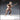 Digital render of an unpainted Human Male Monk miniature in 32mm scale, shown in a dynamic side-on combat pose. The bare-chested male figure grips a diagonal quarterstaff with both hands, rope-wound at the centre, with one knee raised mid-stride and an expression of focused aggression. Simple cloth trousers, rope belt, and sturdy boots complete the look.