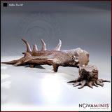 Digital render of the Fallen Tree 02 scatter terrain set by Novaminis — a thorned fallen log with jagged upward-curving spurs and a separate gnarled tree stump with claw-like roots, both unpainted in brown resin tone, shown against a neutral grey background