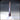 Digital render of a tall stone obelisk scatter terrain piece on a square stepped plinth, shown in three-quarter view with fine stone texture across the shaft — Monument 01 by Novaminis, unpainted resin terrain for 32mm D&D and tabletop RPGs