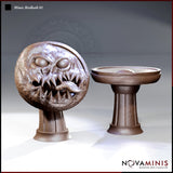 Novaminis Mimic Birdbath 01: two pieces shown side by side — a snarling round-bodied mimic with bulging eyestalks, gaping toothed maw and lolling tongue on a pedestal, beside an innocent-looking stone birdbath.
