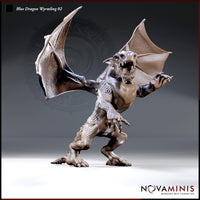 Snarling blue dragon wyrmling rearing upright, wings fully spread, one foreleg raised with claws extended, jaws wide open. Scaled body with pronounced horns and a thick tail. Sculpt by Novaminis.