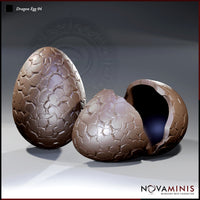 Two Novaminis dragon egg sculpts side by side — one intact with tessellated scale-plate texture across the whole shell, one cracked open with a hollow dark interior and broken rim.