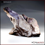 Twisted asymmetric rock spire with a deeply fissured surface, a windswept upper ridge tapering to a jagged point, and a broad eroded base with undercut hollows. Sculpt by Novaminis.