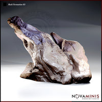 Twisted asymmetric rock spire with a deeply fissured surface, a windswept upper ridge tapering to a jagged point, and a broad eroded base with undercut hollows. Sculpt by Novaminis.