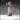 Front view of Hungry Child 02 resin miniature by Novaminis — an unpainted 32mm digital render of a gaunt female figure in a long cross-stitched robe, one arm raised with fingers curled, the other hanging low and clawed, with wild matted dreadlocks and a hollow expression