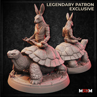 Digital render of an unpainted rabbitfolk monk miniature seated cross-legged in a meditation pose atop a giant tortoise, wearing flowing robes with fingers held in a mudra, shown from front and rear angles on a scenic ground base — labelled as a Legendary Patron Exclusive by M3DM