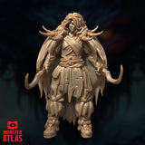 Front-facing digital render of Ravisin the Frost Druid miniature — unpainted resin-coloured sculpt showing a female figure in layered tattered robes with a knotted sash, bone fetishes tied to her shoulders, curved sickle blades at both sides, and wild hair adorned with carved bone ornaments