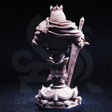 Rear view of unpainted grey resin bust of Ridan the Everlasting — showing intricate chainmail texture on the cloak, layered pauldrons with engraved detail, the spiked crown from behind, and the ornate cracked display base