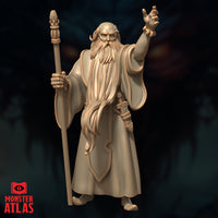Front-facing digital render of Ringlerun wizard miniature by Monster Atlas — elderly bearded mage in long robes, staff raised in left hand, right arm extended with fingers splayed mid-incantation, 32mm scale