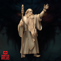 Side-angled digital render of Ringlerun wizard miniature — full body view showing robes in heavy folds, bare feet, raised arm and staff pose, Monster Atlas sculpt in tan render colour