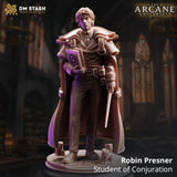 Robin Presner Student of Conjuration 32mm resin miniature by DM Stash — digital render showing the front of an unpainted figure in a long layered academic cape, holding a conjuration spellbook with arcane seal and a slender wand, set against a candlelit hall background