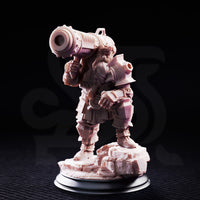 Dwarven cannoneer miniature gripping a large shoulder-mounted cannon with both hands, heavy segmented plate armour with pauldrons and bracers, standing on a craggy rocky base. By DM Stash.