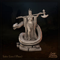 Front view of Sahira Vaess 35mm resin miniature by Great Grimoire — an unpainted grey resin sculpt of a crowned female warrior standing atop a coiled draconic serpent, great axe resting across her shoulders, wearing ornate hip armour and flowing robes, on a scenic stone base with coins and ritual bowls