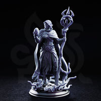 Saratha the Watchful by DM Stash — tall drow priestess holding a twisted trident-topped staff and raising an orb in her other hand, wearing a fur-collared cloak over layered cloth wrappings, standing on a tangled root base.