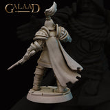 Rear view of the same unpainted grey resin Queen's Guard Sergeant miniature showing the full sweep of the dramatic flowing cape, detailed segmented armour on the back and shoulders, plumed helmet, and the longsword extended outward from the lowered left arm, set on a cracked cobblestone scenic base