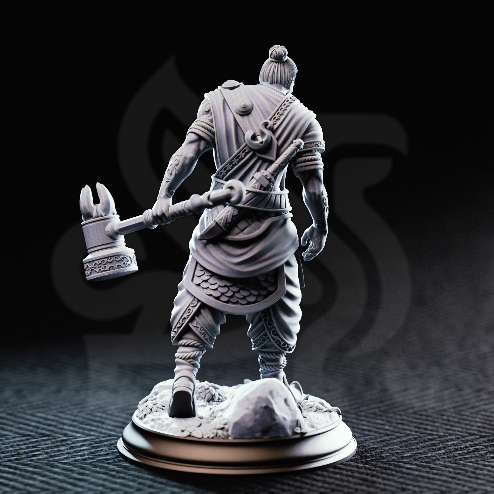 Rear view of the unpainted grey resin Sindan the Southern Hammer miniature, showing the detailed back of his layered robes, rope-wrapped belt, scale armour skirt, and the ornate scrollwork on the head of his maul