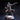 Front view of an unpainted grey resin miniature of a male human gunslinger in a quilted coat and studded pauldrons, raising a flintlock pistol in his right hand and holding a small arcane orb device in his left, mid-stride on a cobblestone rubble base — 32mm scale