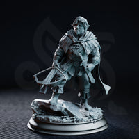 Halfling ranger miniature holding a crossbow at the ready, wearing layered runic leather armour and a billowing cloak, standing on a rocky scatter base with dried leaves. Sculpt by DM Stash.