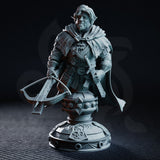 Bearded halfling ranger bust holding a crossbow, wearing layered armour and a wide cloak. Expression is calm and watchful. Ornate heraldic display base. Sculpt by DM Stash.