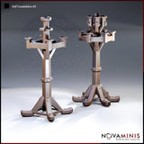 Two tall iron candelabras by Novaminis: left has a square four-arm crown with single central socket; right has a clustered six-socket multi-tiered crown. Both stand on bolted tripod bases with splayed feet.