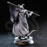 Unpainted grey resin miniature of The Captain tiefling veteran soldier — rear view highlighting scaled travelling cloak texture, tiefling tail, articulated gauntlets, and banner-pole held across the shoulders