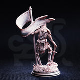 Rear three-quarter view of the unpainted grey resin Lost Crusader 2 miniature, showing the billowing banner, chainmail detail across the back, skeletal limbs, and the debris-covered scenic base