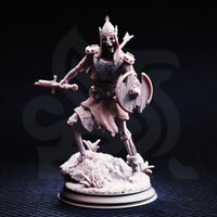 Front view of an unpainted resin Lost Crusader 3 miniature at 32mm scale — a crowned skeleton warrior in tattered chainmail advancing with a sword raised in its right hand and a cracked round shield held low in its left, striding forward over a rubble and dead-growth base