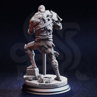 Rear view of Plague Carrier 2 — unpainted grey resin miniature showing the back detail of the skeletal undead warrior, including exposed sinew texture across the back, chainmail at the hips, a shoulder strap, and the rubble-strewn scenic base